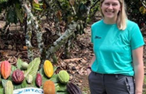 Brockmann outside next to table of cocoa pods