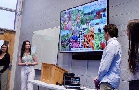 students presenting in front of a screen