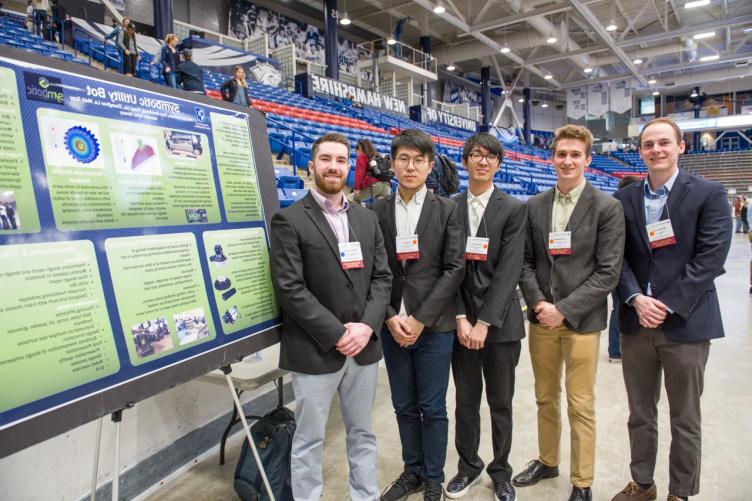 Five CEPS students standing beside a poster at URC