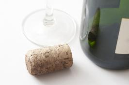 一个葡萄酒瓶和软木塞旁边的一个葡萄酒杯