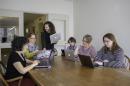 永利app新版本官网地址图书馆的教职员工围坐在一张桌子旁