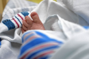 一个新生儿裹着毯子躺在医院里.